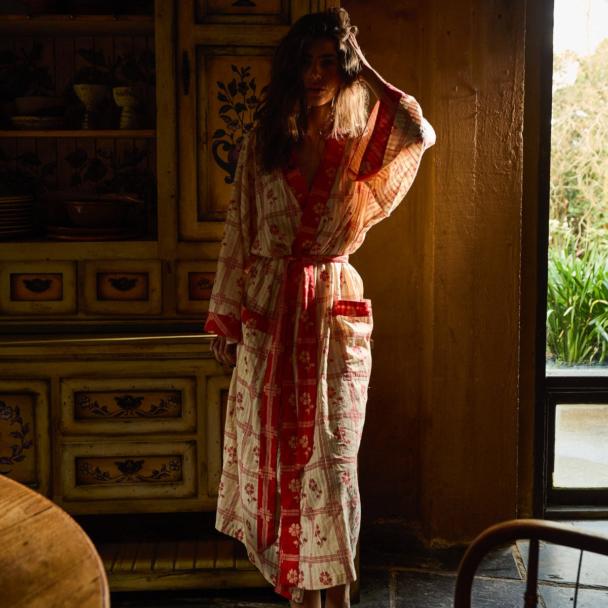 Bonny Cotton Robe in Poppy — full-length front view showing red floral check print, pocket detail and tie belt