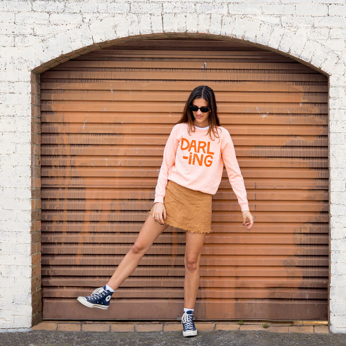 Peach sweater with orange writing from castle