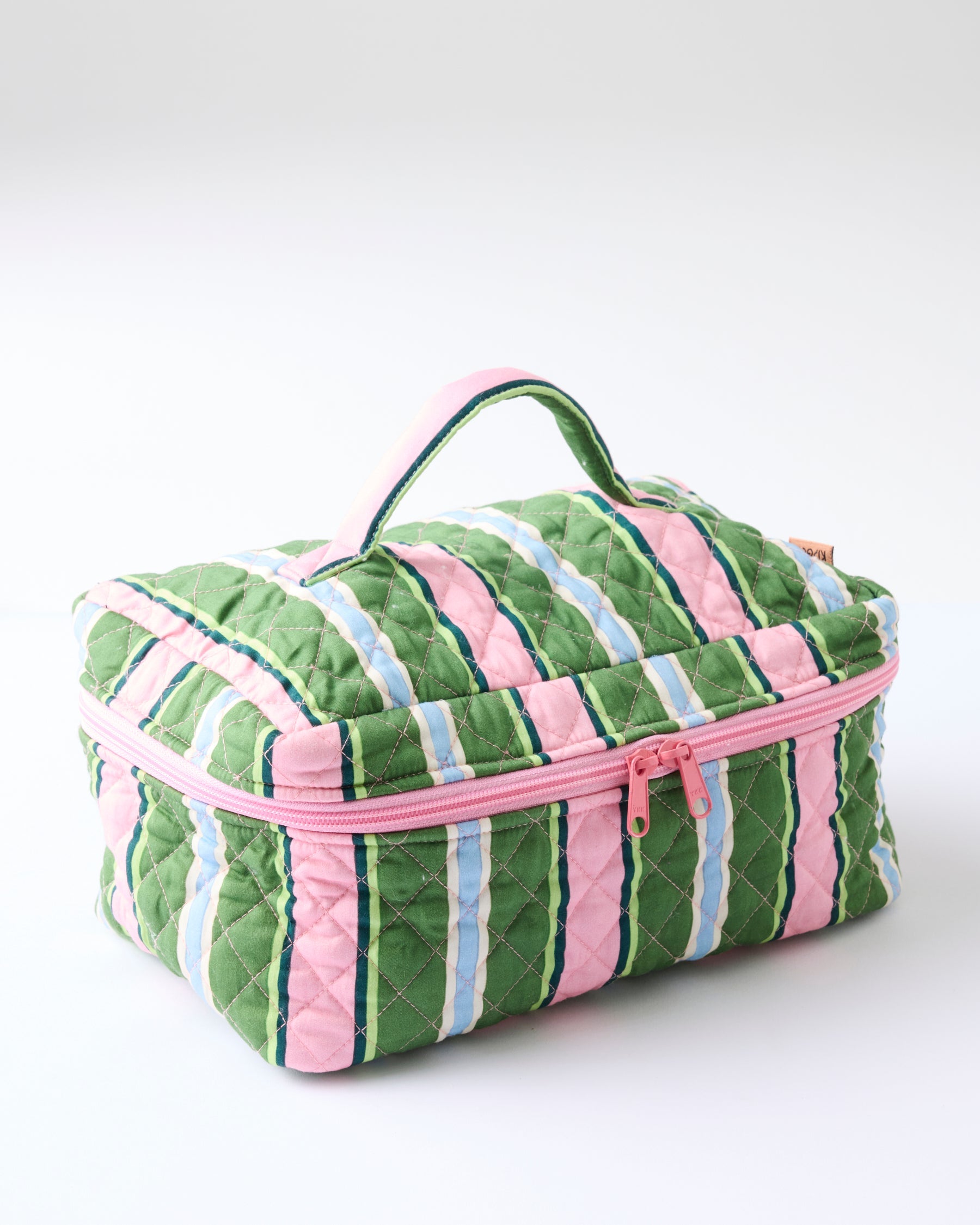 Side angle of Kip & Co Cactus Stripe Quilted Cotton Toiletry Case displaying diamond quilted texture and handle
