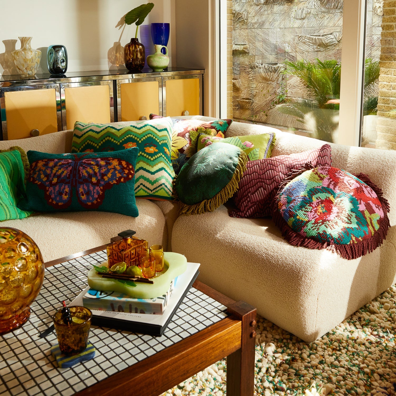 Wide angle view of Calina Knit Cushion Verdant styled with colorful throw pillows on sectional sofa