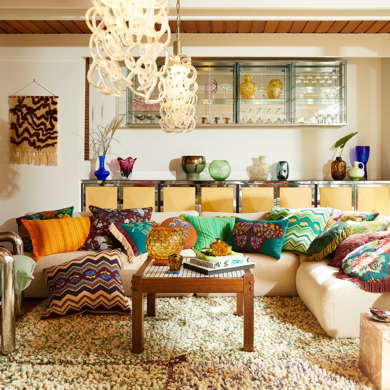 Living room styling shot showing multiple Calina knit cushions including Verdant green chevron pattern