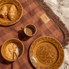 Close-up of Camp Picnic Rug showing hemp gingham pattern with picnic dishes and fringe edge detail