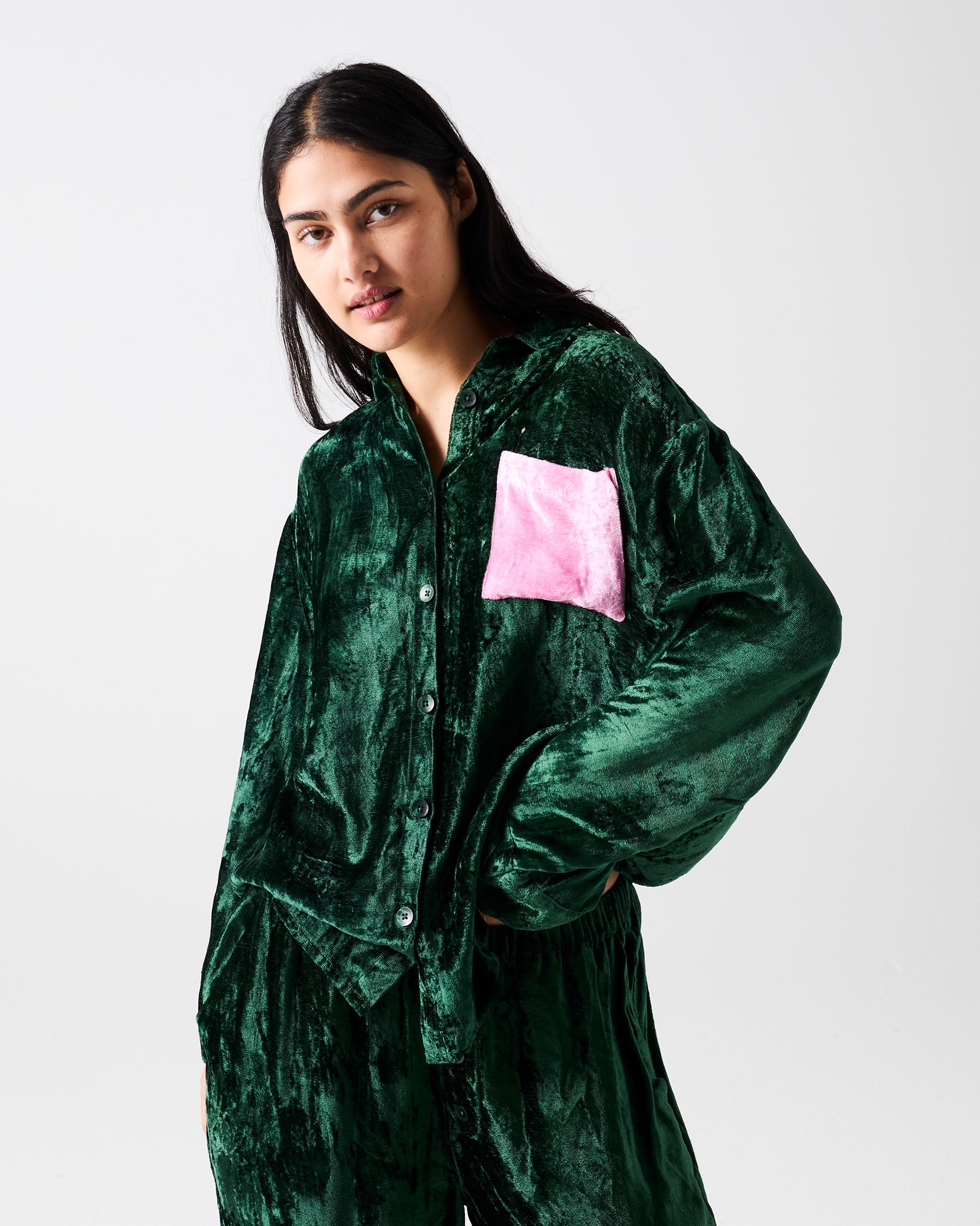 Three quarter view of Candy Pine velvet pajama shirt showing pink chest pocket and button closure