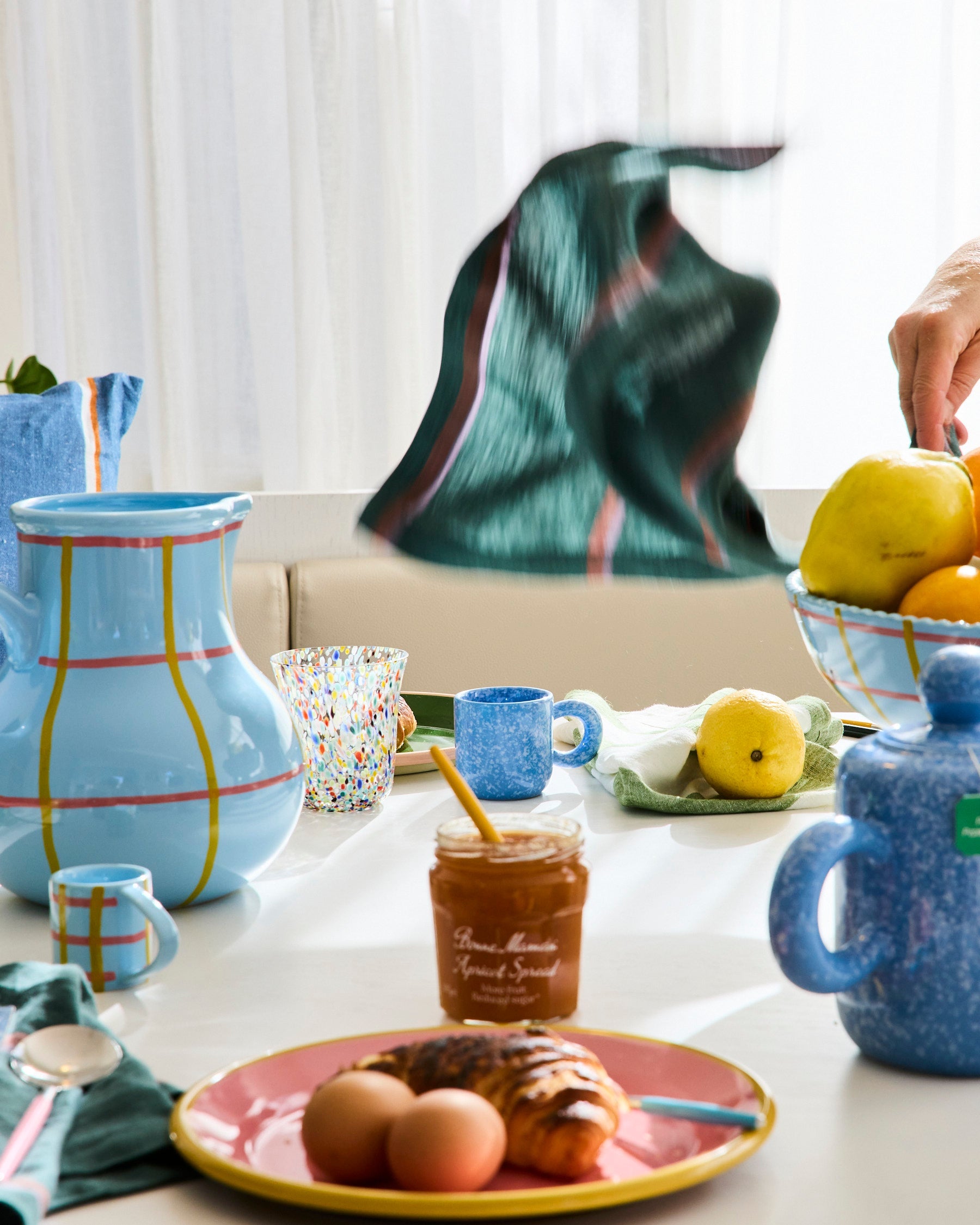 Blue marbled espresso mug in styled kitchen scene with colorful ceramic tableware and fruit