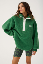 Front view of Celeste Pullover in tide green showing oversized fit and white quarter zip closure