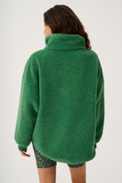 Back view of green Celeste Pullover displaying high collar and oversized silhouette