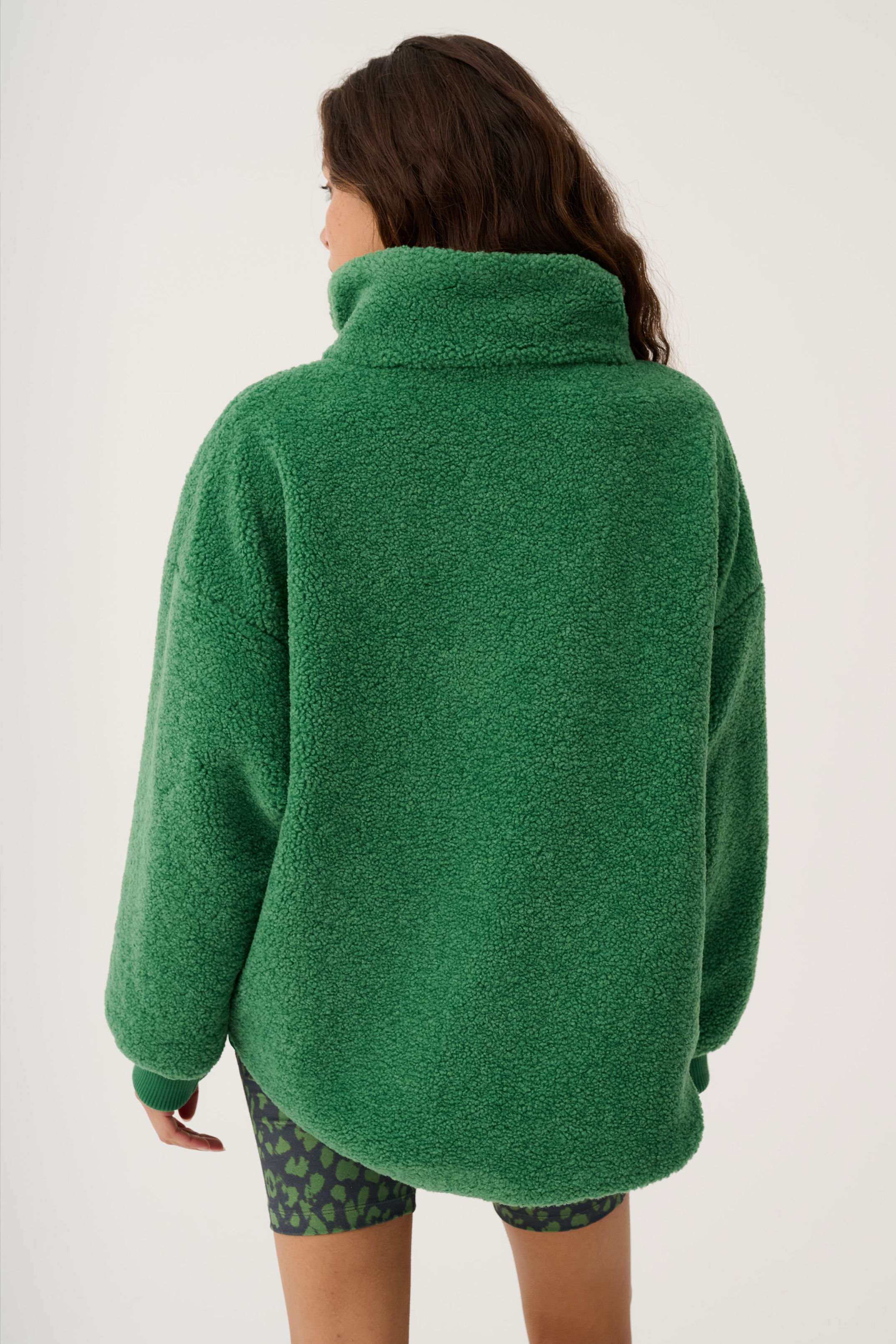 Back view of green Celeste Pullover displaying high collar and oversized silhouette
