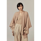 Model wearing tan Clara Wool Blend Poncho by Helen Kaminski