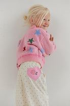 Side view of Cleo Pant showing pink heart patch and small rose print on cream fabric