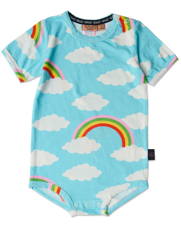 Flat lay of Kip & Co Cloudy Dayz Organic Short Sleeve Romper – light blue romper with playful white clouds and rainbow print.