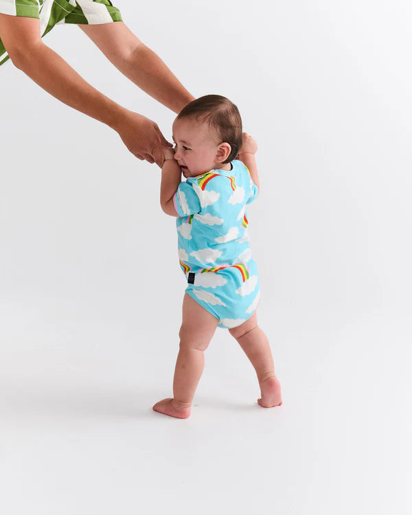 baby wearing Kip & Co Cloudy Dayz Organic Short Sleeve Romper with rainbows and clouds on light blue fabric