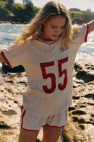 lady wearing organic cotton pointelle fabric tee in cream with red "55" print across the front
