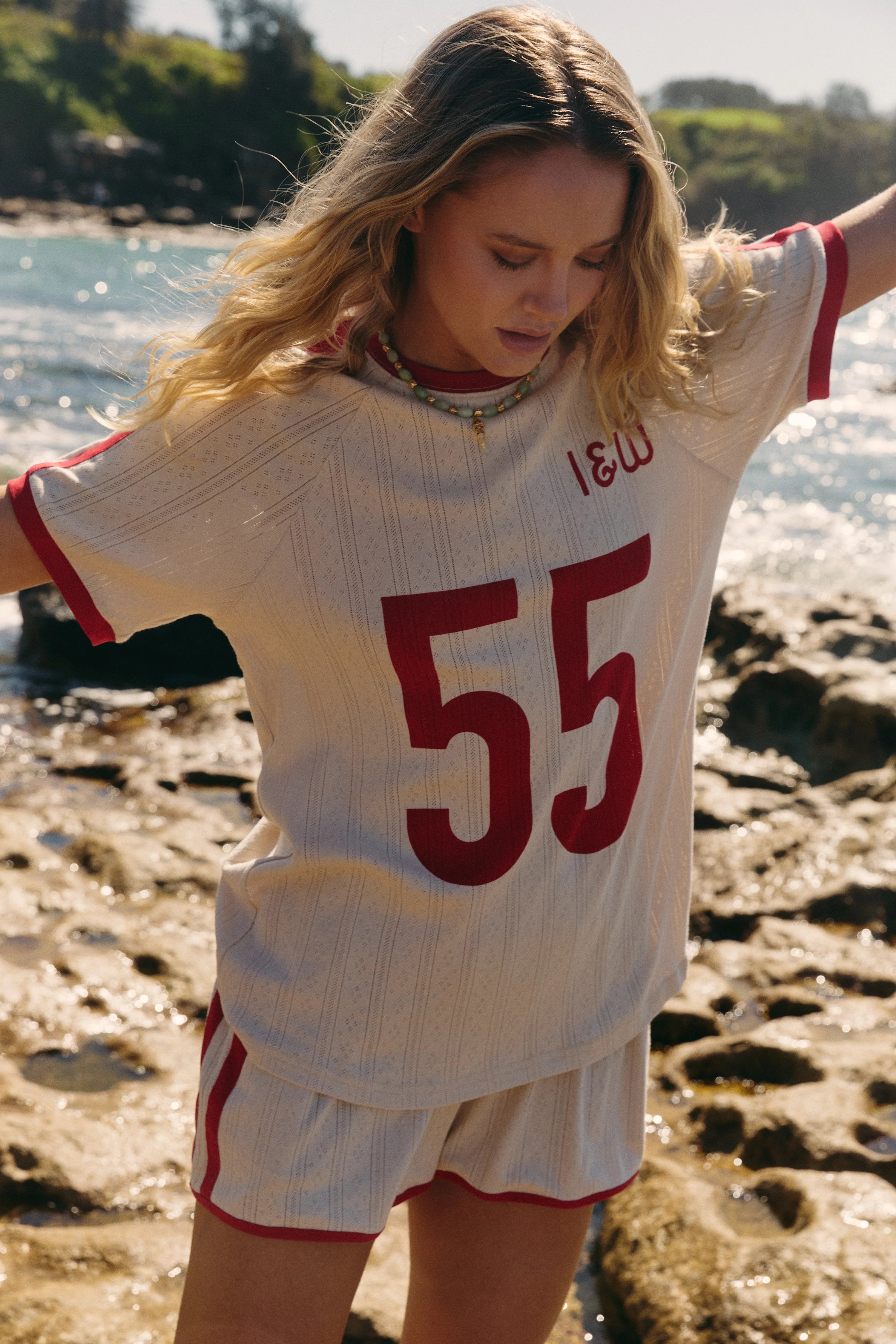 lady wearing organic cotton pointelle fabric tee in cream with red "55" print across the front