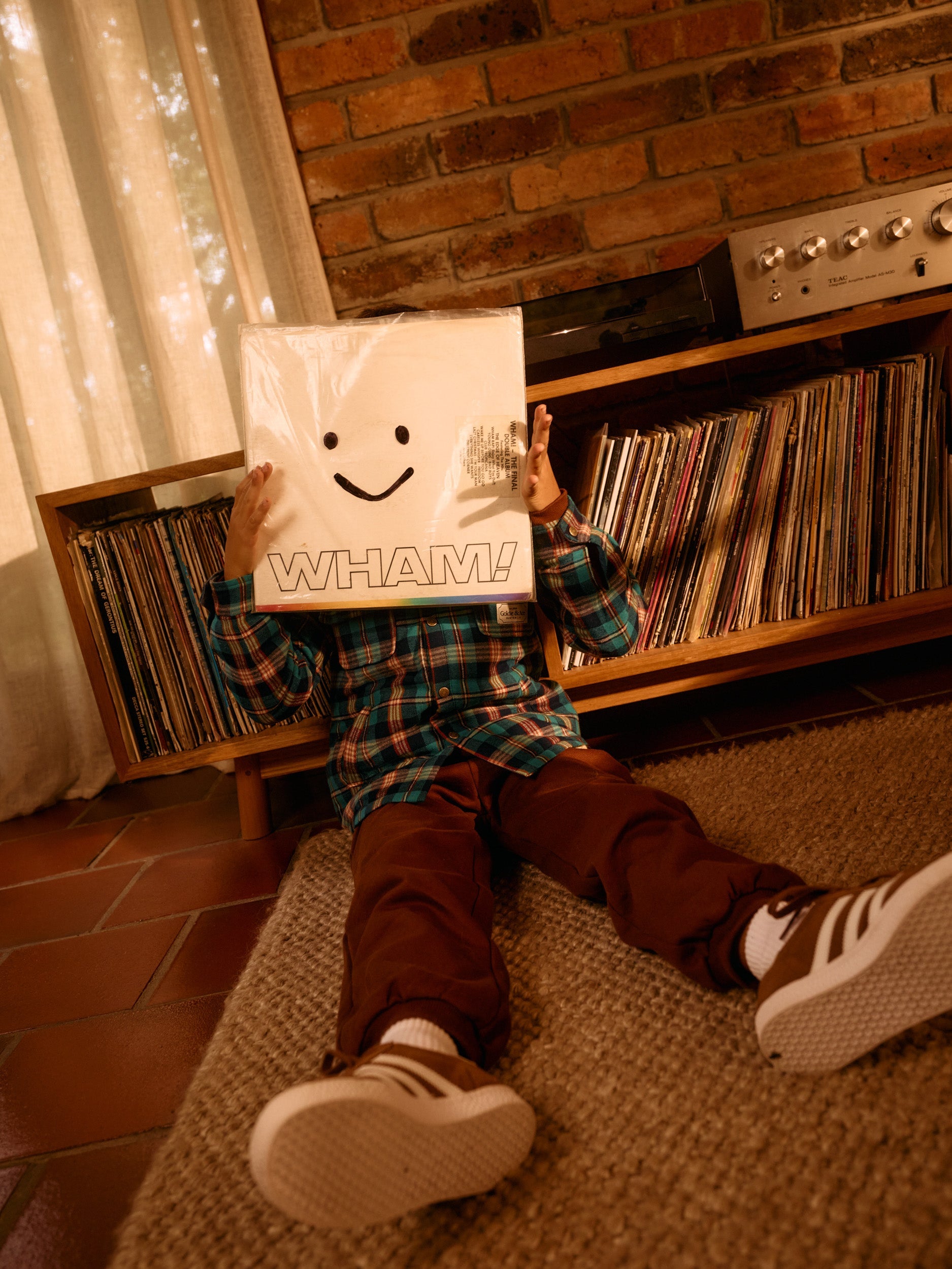 Brown embroidered sweatpants styled with plaid shirt showing comfortable relaxed silhouette