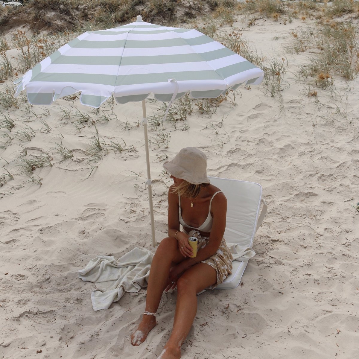 Compact beach umbrella folded in black carry bag with shoulder strap for easy transport and storage