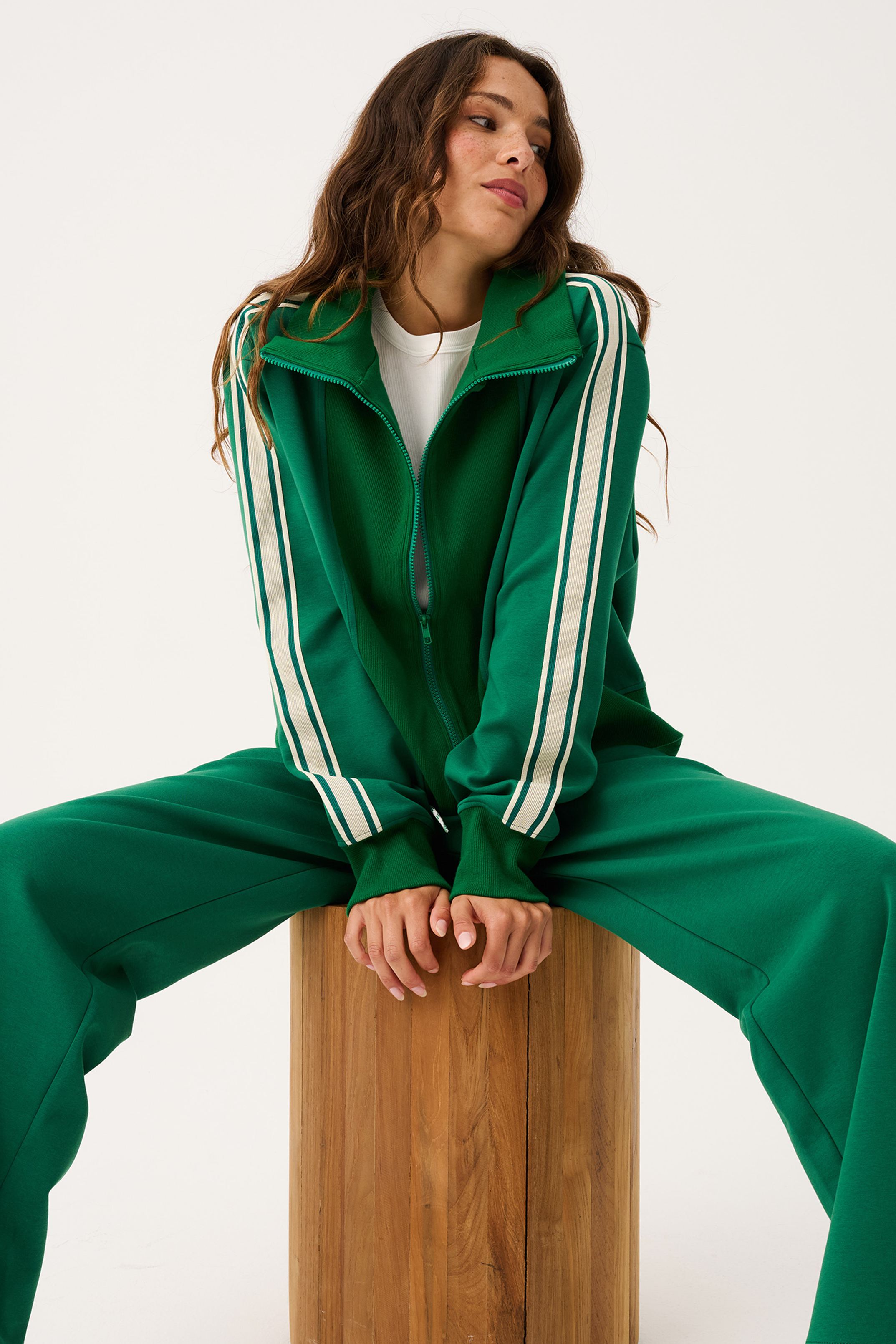 Full tracksuit view of green Corey Zip Through Sweater worn open over white tee with matching pants