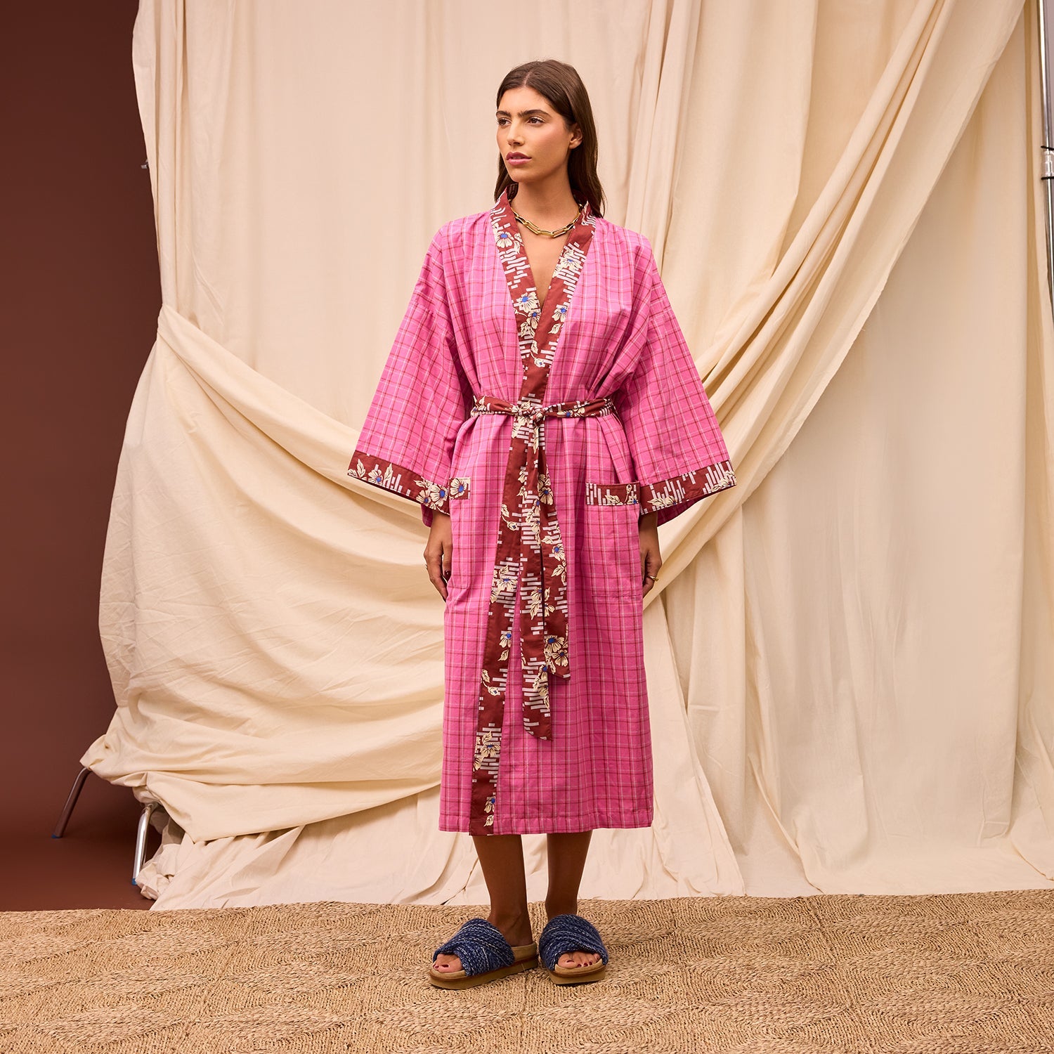 Model wearing Sage & Clare Cosmin Cotton Robe in pink plaid with colorful maximalist detailing and wide bell sleeves
