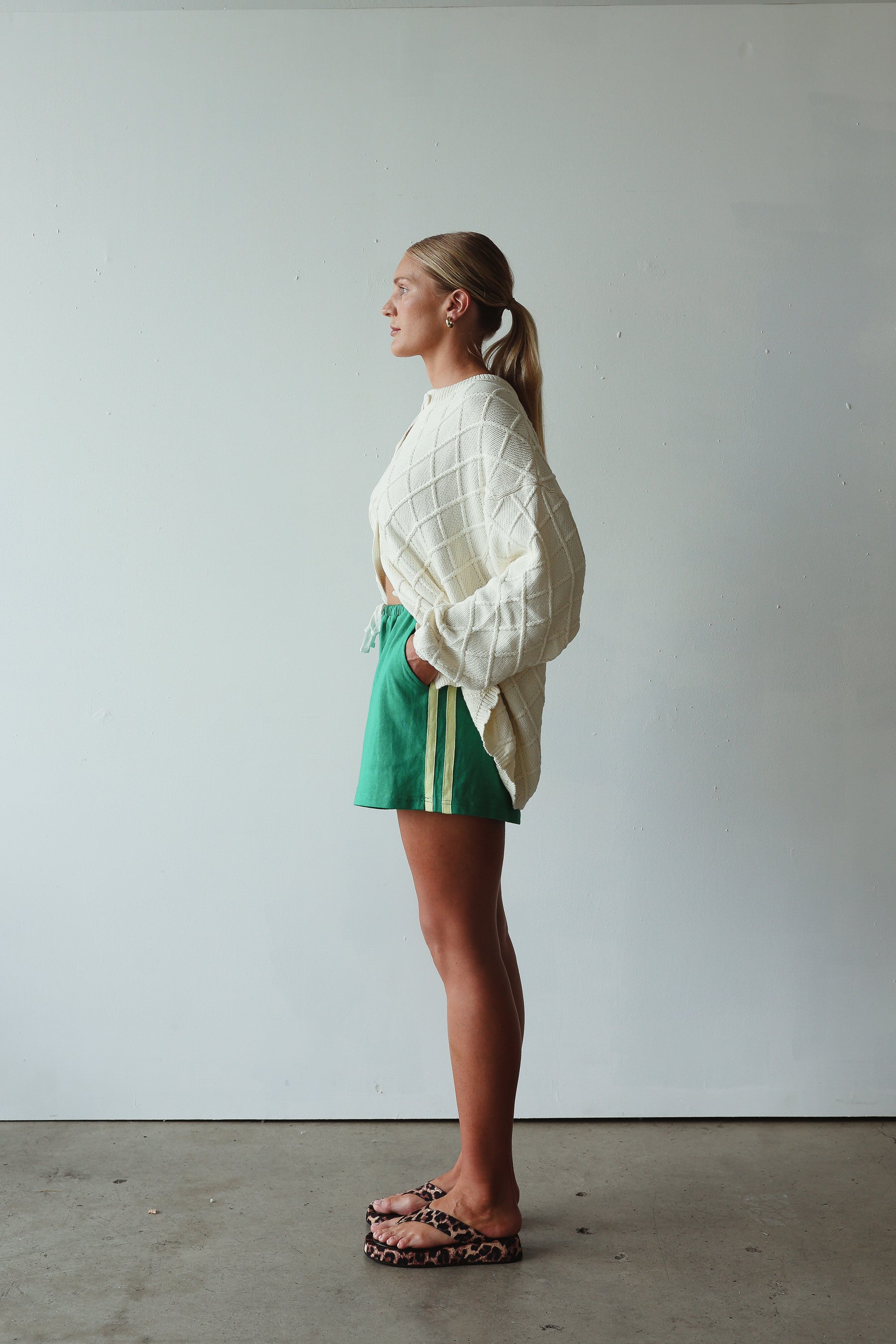 side profile of model wearing Crochet Knit Cardigan - cream by By Billie