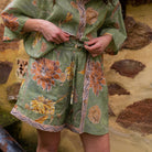 Close-up detail of drawstring waist and hand-painted dahlia floral pattern on organic cotton shorts