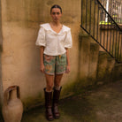 Front view of model wearing Dahlia Shorts in moss with white top showcasing contrast hem detail