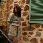 Model posing in complete Dahlia set showing coordinated moss green floral organic cotton pieces