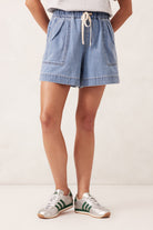 Person wearing a light blue denim shortswith a white background - Darcy Relaxed Everyday Short Mid Wash Blue by Ceres Life