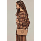 model holding bag Dawn Raffia Crossbody by Helen Kaminski