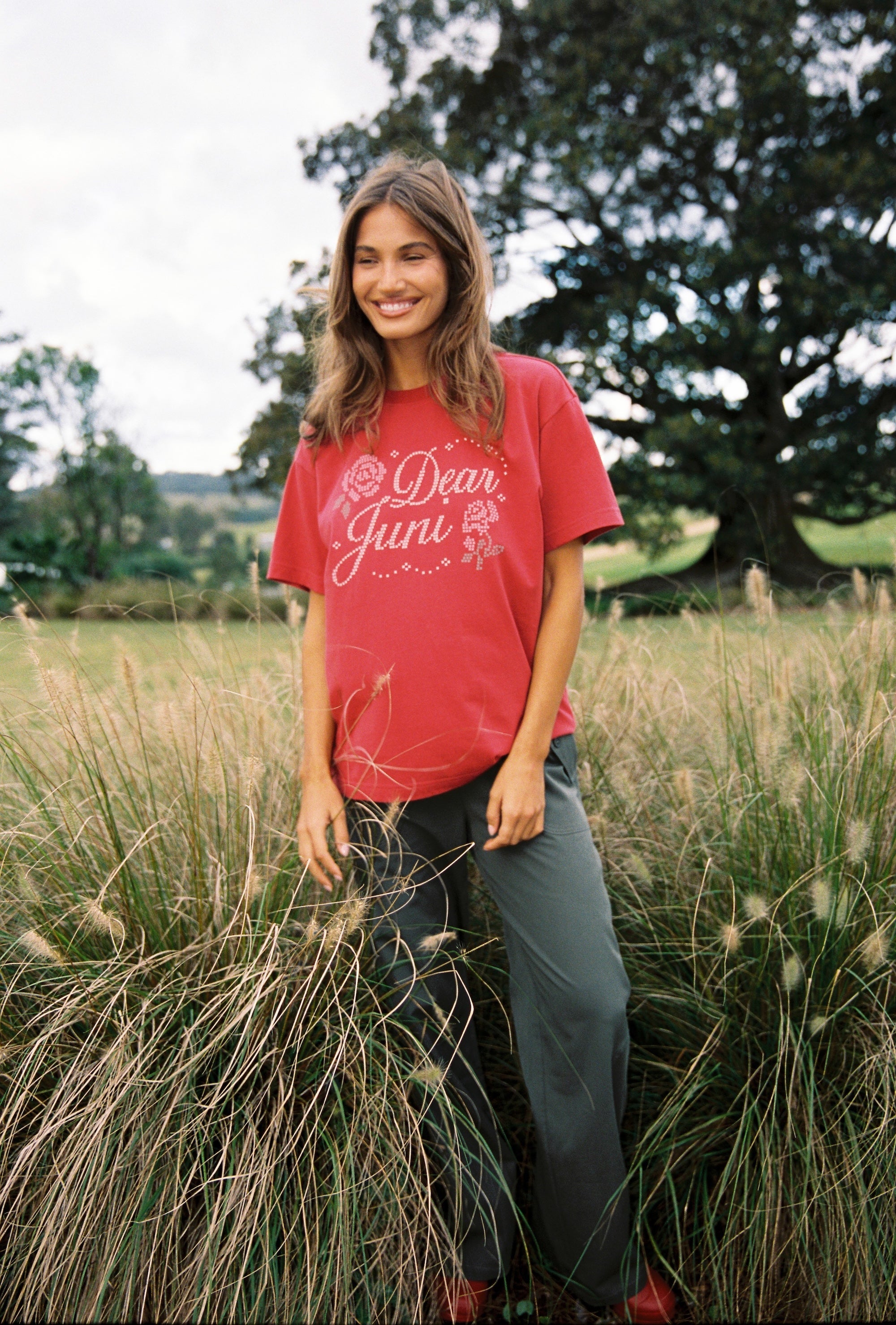 Front view of red Dear Juni Tee showing rhinestone Dear Juni text and rose graphics in chilli shade