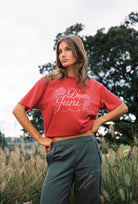 Side angle of red Dear Juni Tee displaying rhinestone embellished lettering and floral motifs