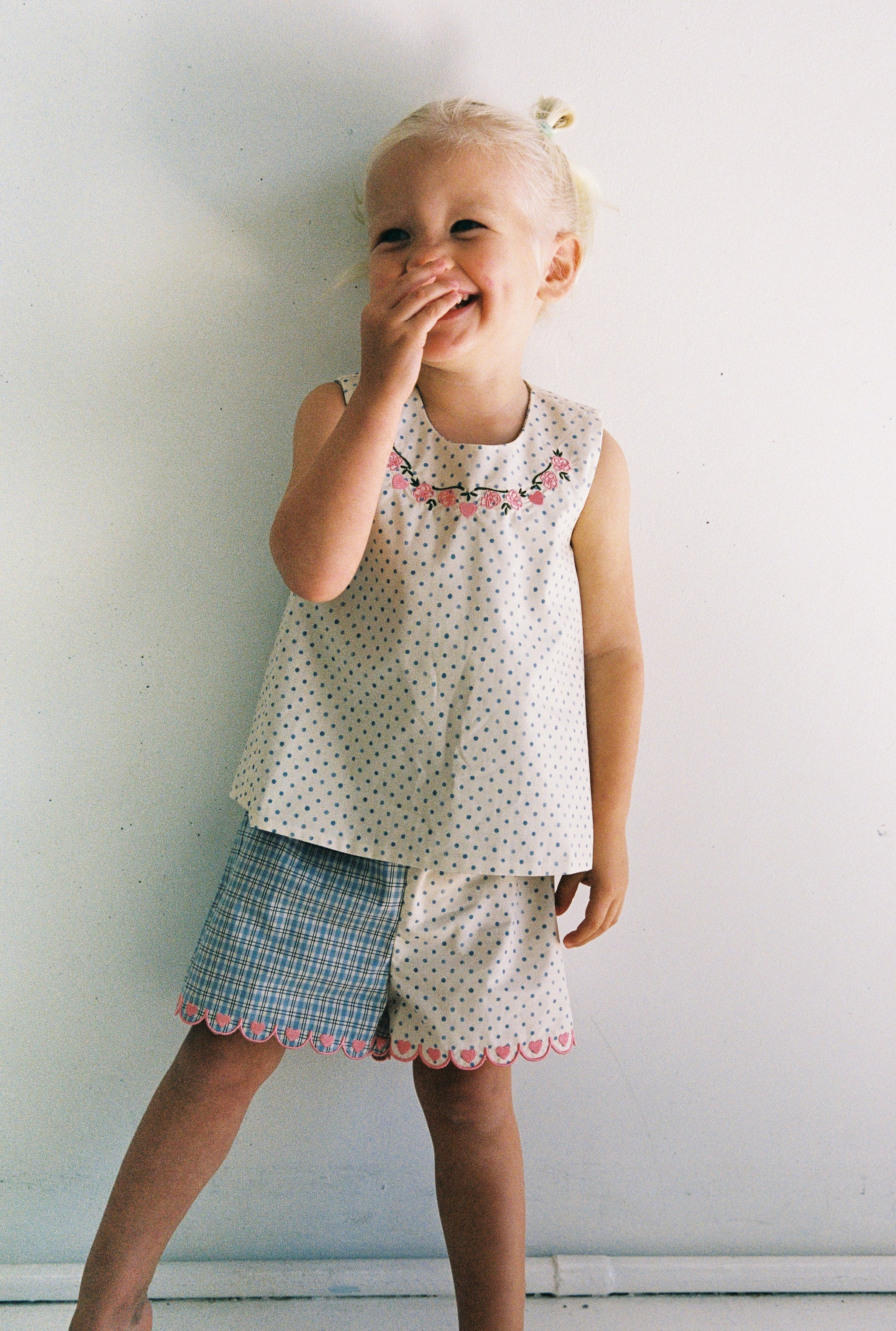 girl wearing cotton top with pink embroidery