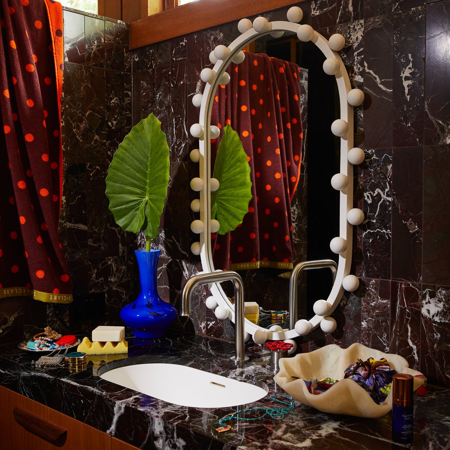 Aspen Gold wave soap dish on a dark marble bathroom vanity with a decorative mirror and styling accessories
