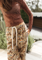 Close-up detail of Deserted Pant waistband showing drawstring tie and western themed print with cowboys and cars