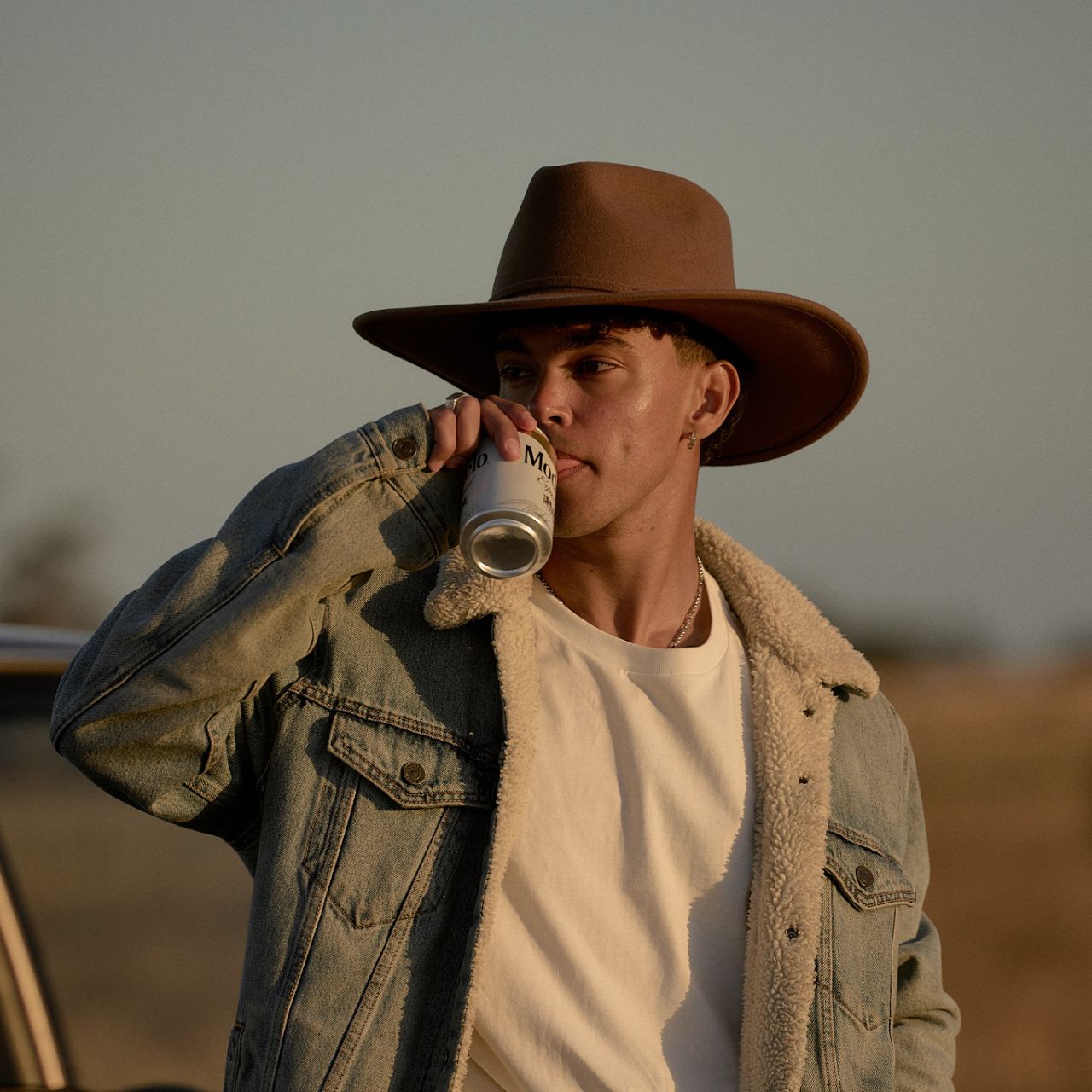 Front portrait view of dusty brown outback hat with wide brim creating face-framing shadow