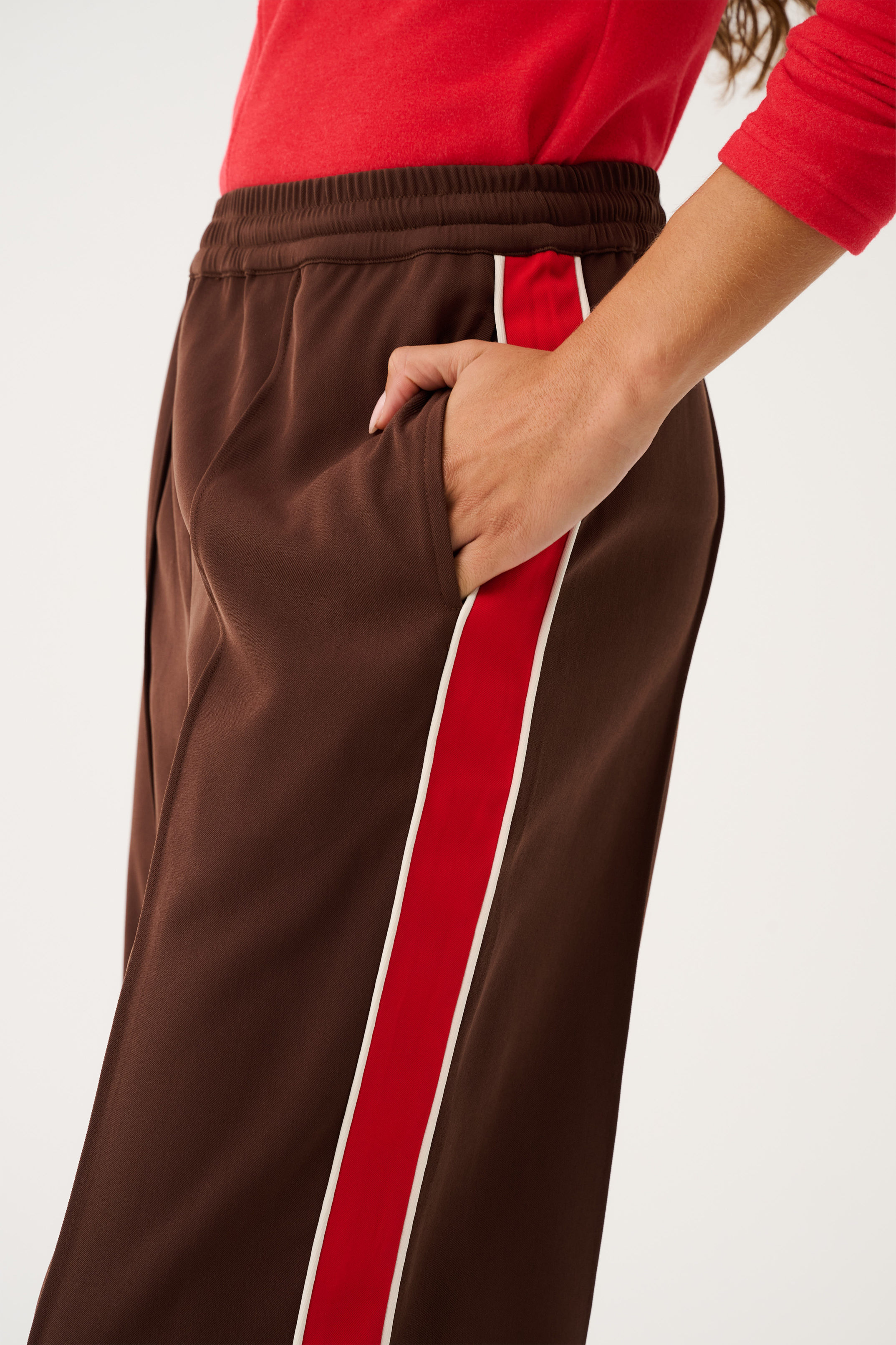 Close-up of Dusty Pant pocket detail showing elastic waistband and red stripe running along side seam