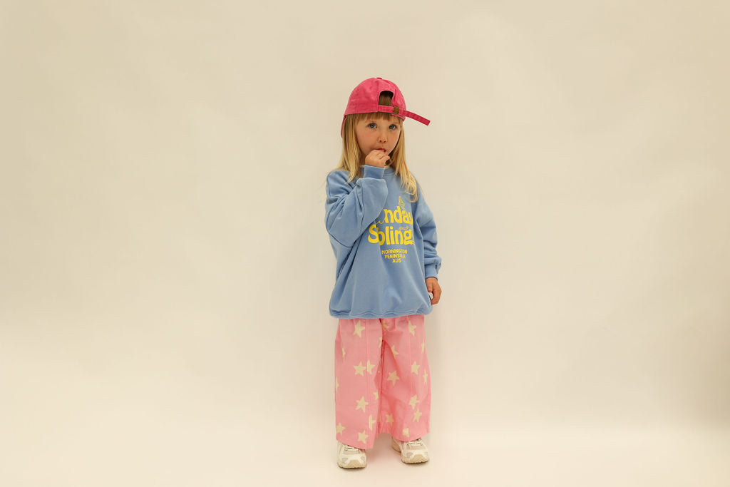 Back three-quarter view of pink Dusty Star Pants with yellow stars and elastic waistband