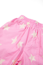 Close-up detail of Dusty Star Pants showing yellow star print on pink fabric and relaxed leg fit