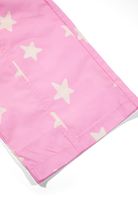 Side profile view of pink Dusty Star Pants with yellow star pattern in casual styling