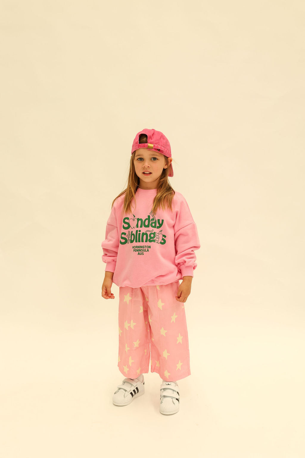 Front view of child wearing blue sweatshirt with pink Dusty Star Pants showing color coordination