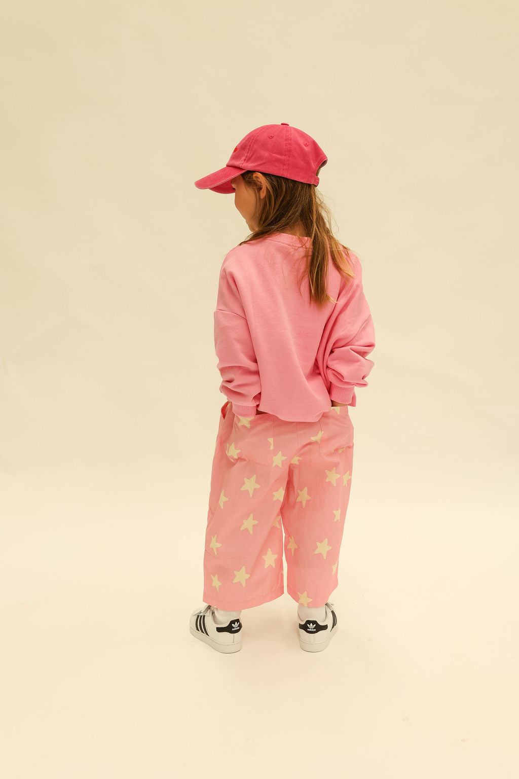 Close-up of pink fabric with yellow star pattern showing textile detail and hemmed edge