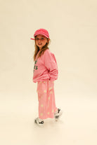 Flat lay of Dusty Star Pants in pink showing full silhouette and yellow star print pattern
