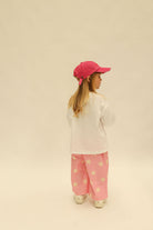 Front view of pink Dusty Star Pants with yellow star pattern and elastic waistband on child model