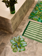Dutch Floral Green Bath Mat positioned in luxury bathroom with marble surfaces and floral accents