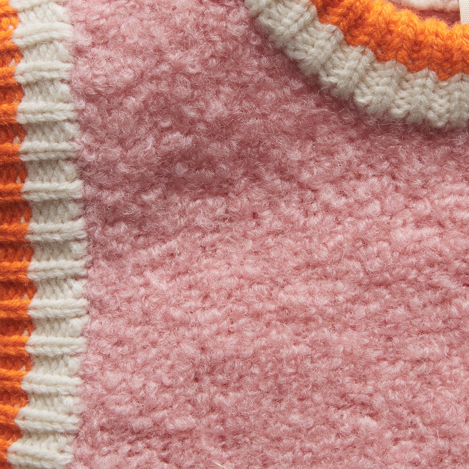 Close-up detail of blush knit fabric texture showing soft fuzzy yarn construction