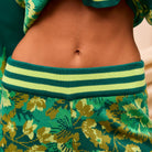 Detail shot of Eliza Knit Pants waistband showing green and yellow striped ribbed knit construction