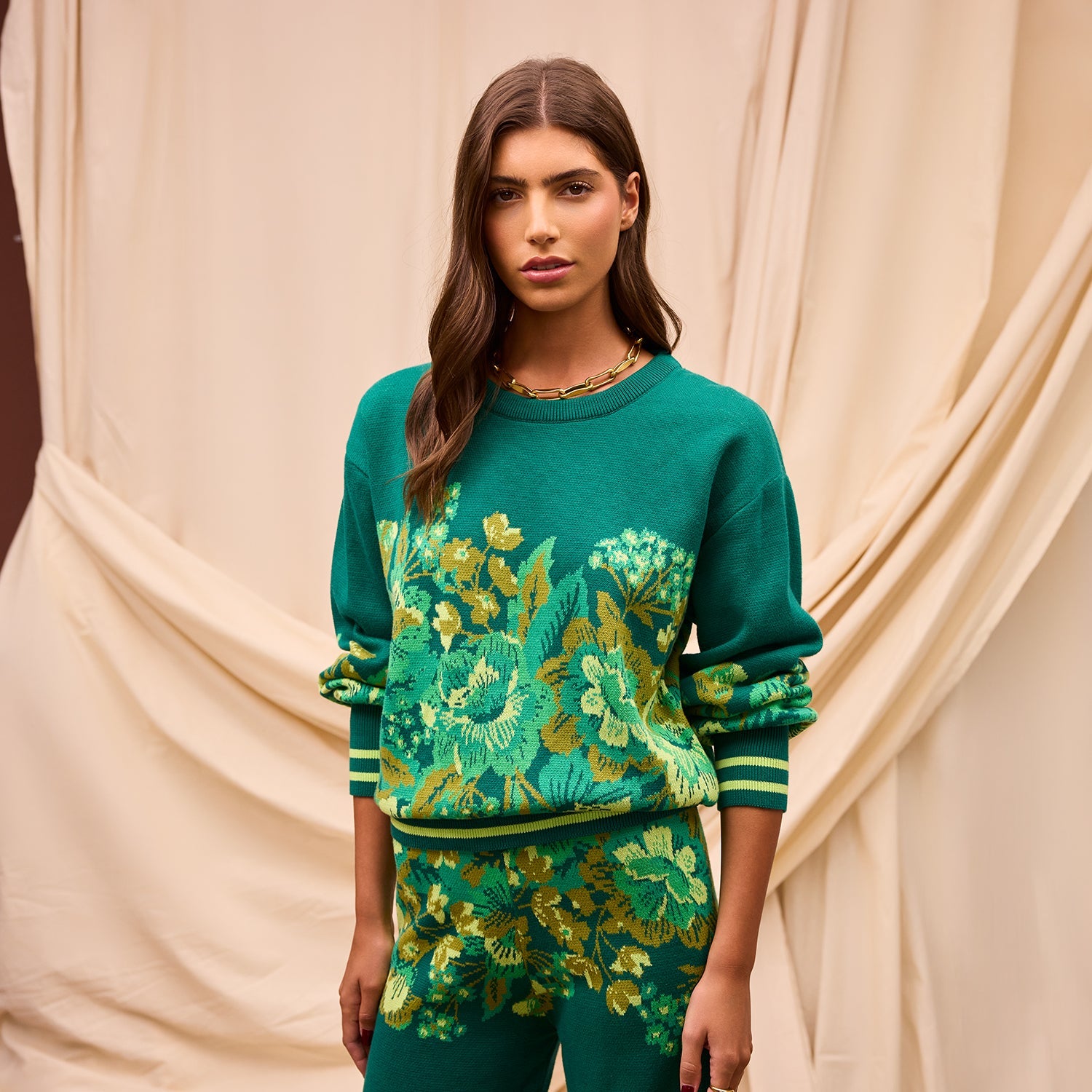 Front view of Eliza Knit Sweater showing botanical print and striped ribbed cuffs on model