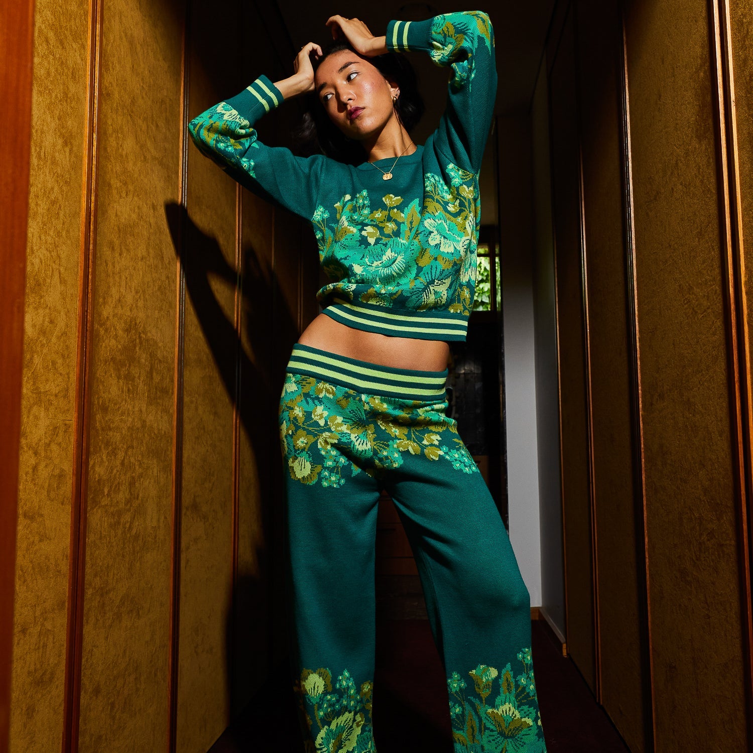 Model wearing Eliza Knit Sweater with arms raised showing fit and floral print design