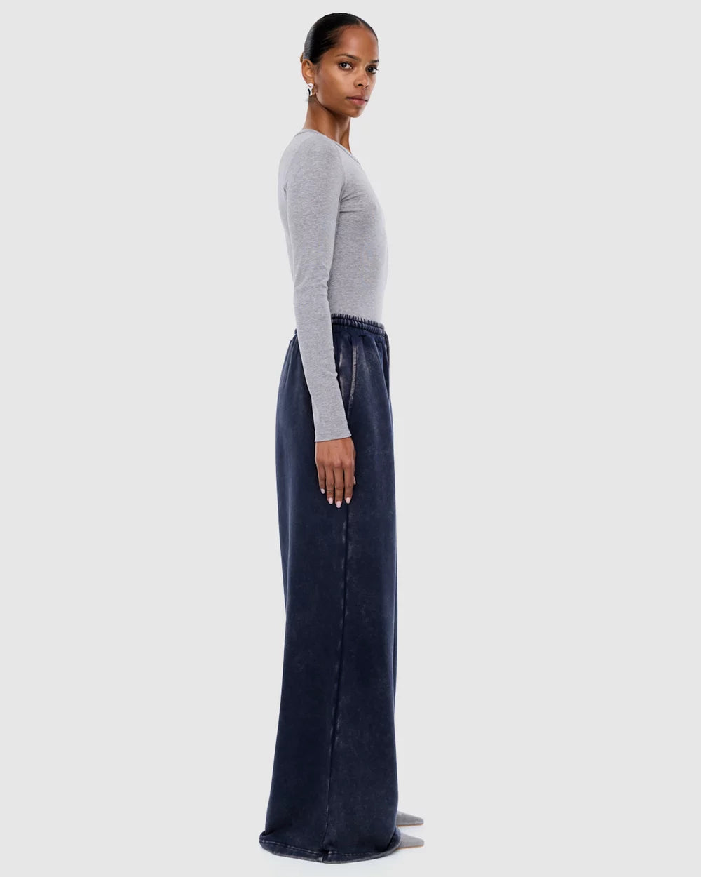 Profile view of washed ink track pants showing loose fit and elastic waistband detail
