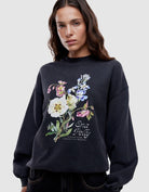 Woman wearing Ena Pelly black vintage bouquet hoodie showing relaxed oversized fit and drop shoulder styling