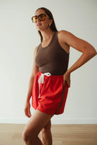 Red shorts with brown stripe by By Billie