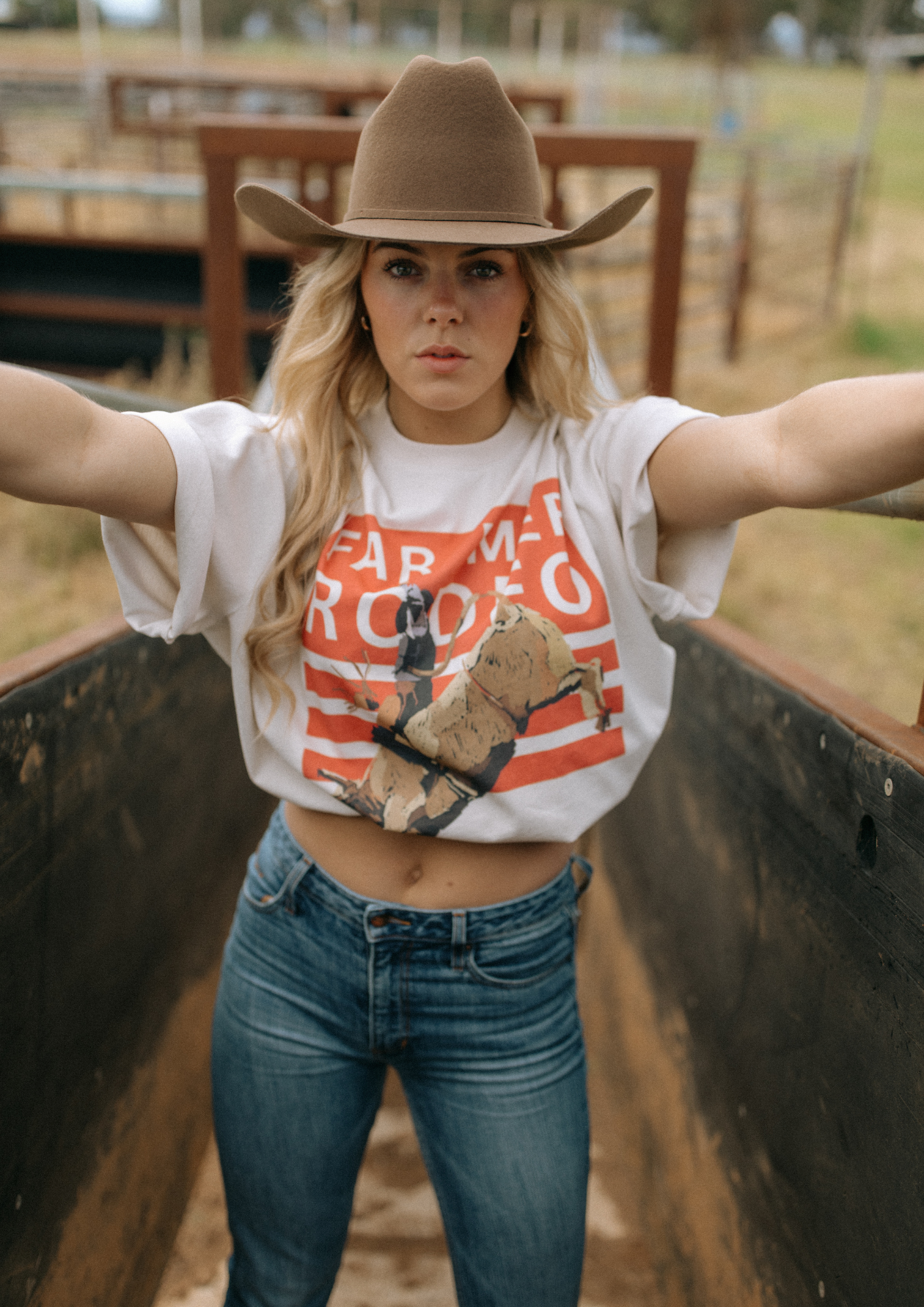 Front view of Rodeo Box Tee showing orange and white rodeo graphic with bull rider design